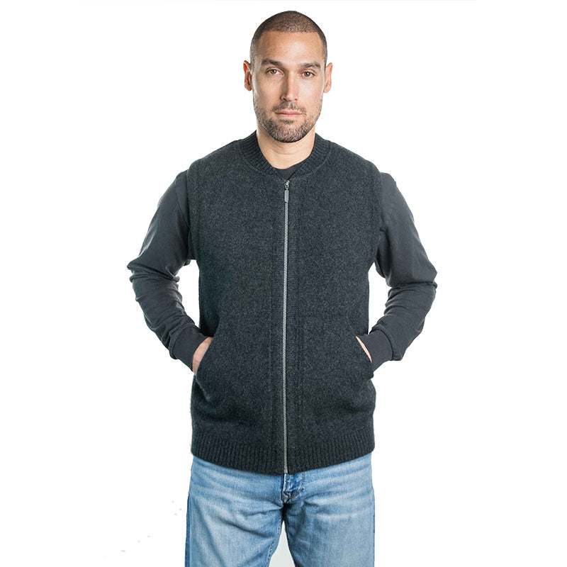 Man wearing a dark grey UGG knit zip vest layered over a long sleeve shirt, warm casual winter vest styled with denim for everyday wear in Australia